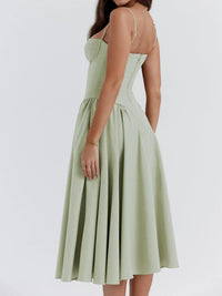 Ruched sweetheart neck cami dress in light green, showcasing a flowing skirt and adjustable straps from a back view.