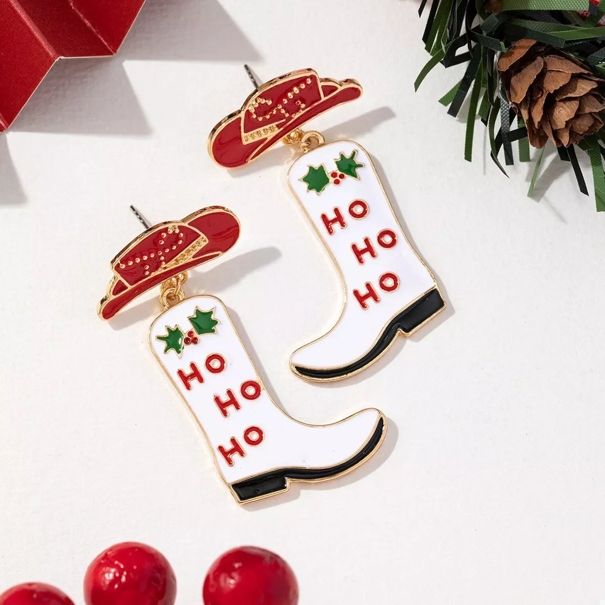 Christmas Cowboy Hat and Boot Dangle Earrings featuring festive red cowboy hat and white boots with 'HO HO HO' design