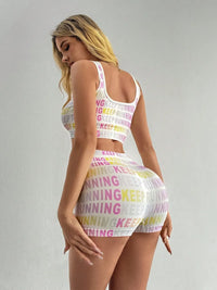 Woman wearing a letter printed wide strap top and shorts active set, featuring a colorful 'keep running' design.
