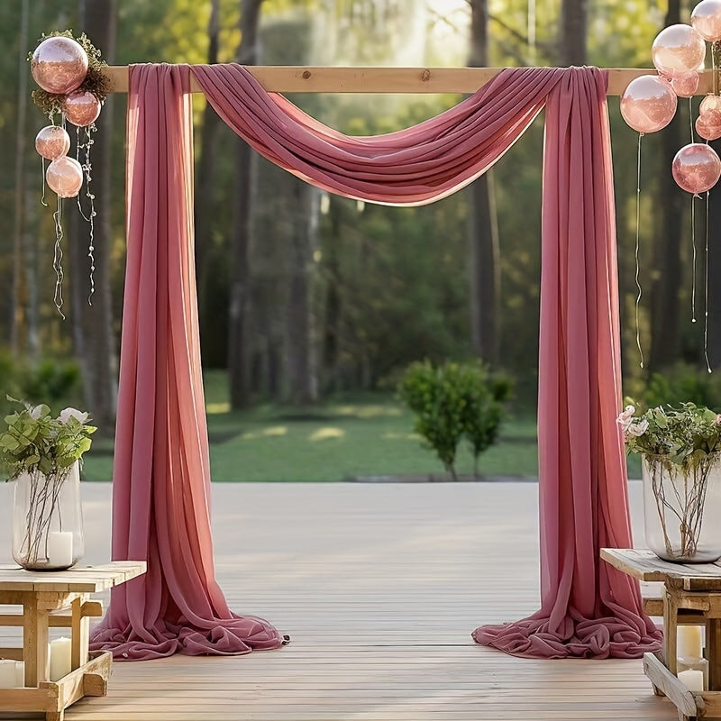 an outdoor ceremony with pink drapes and hanging lanterns