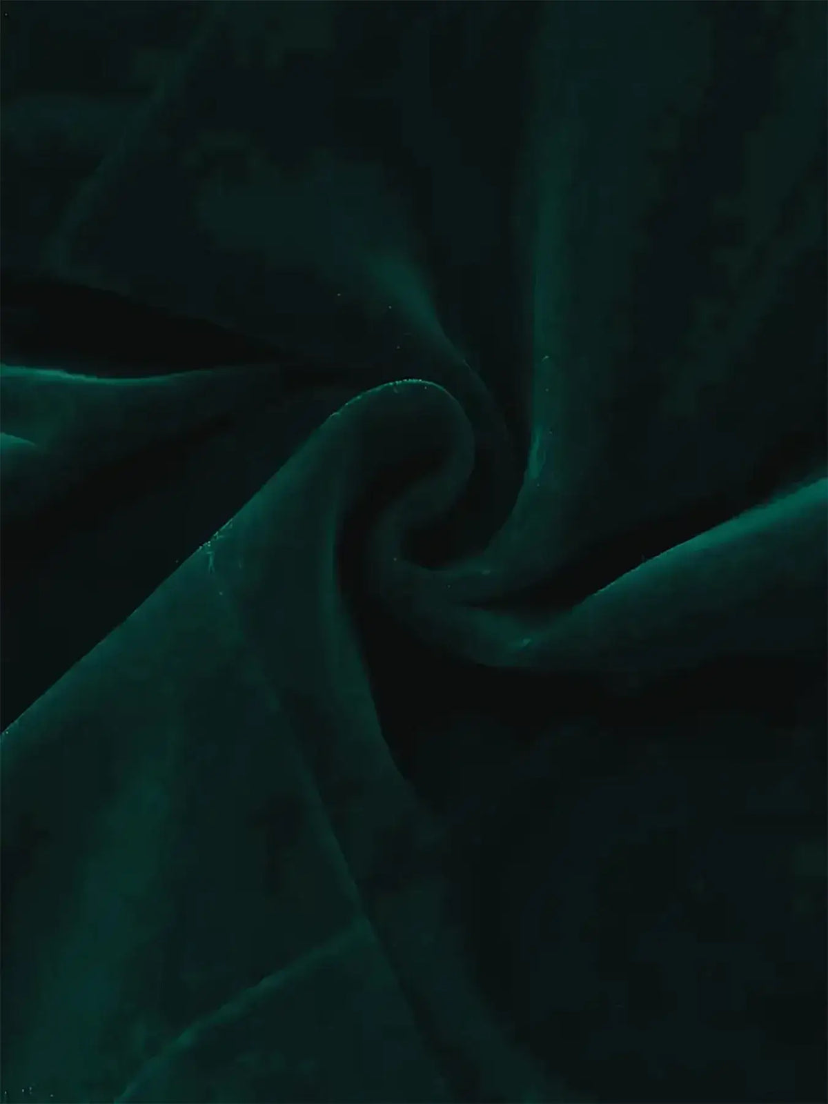 Luxurious green velvet fabric, showing a smooth and rich texture ideal for bridal and formal wear.