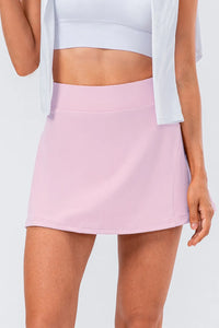 High waist pleated active skirt in soft pink, featuring a stretchy material for comfort and movement.