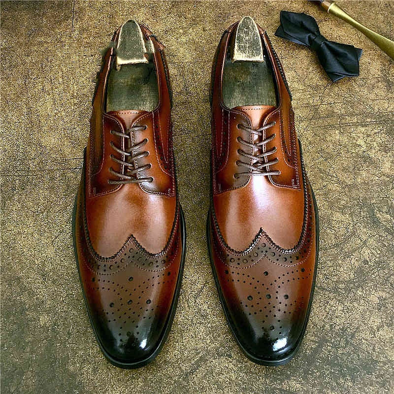 Genuine leather brogue business shoes in brown, featuring elegant detailing and a pointed toe for formal attire.