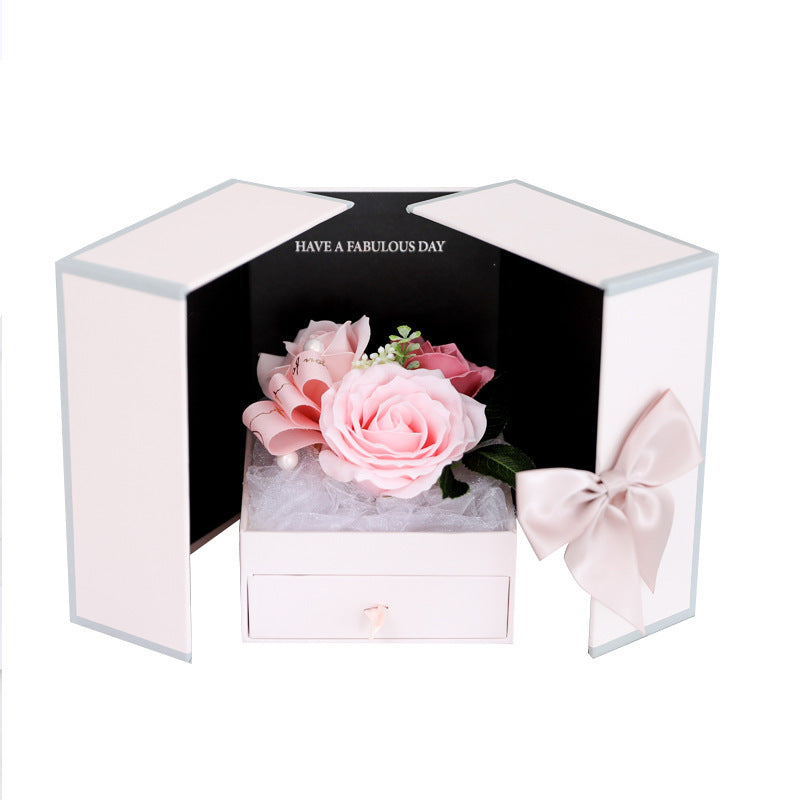 a white box with a pink flower inside of it