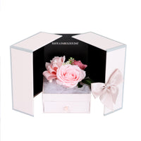 a white box with a pink flower inside of it