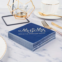 a stack of blue and gold wedding napkins on a table