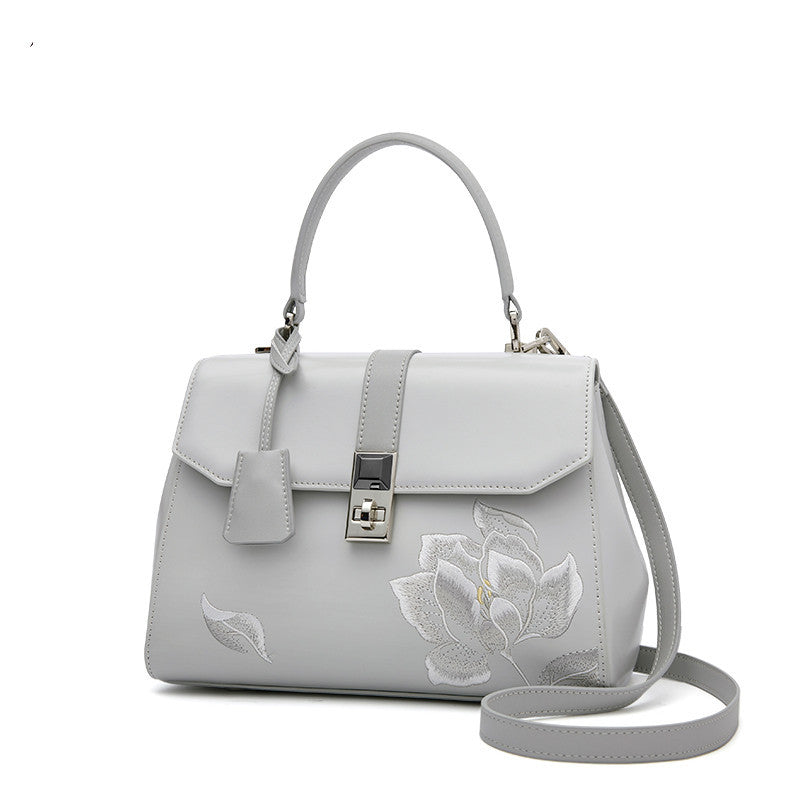 a white purse with a flower on it