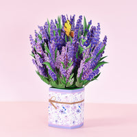 a bouquet of purple flowers in a white vase