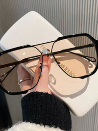 Oversized UV protection sunglasses being held above a glasses case, perfect for luxurious weddings and formal occasions.