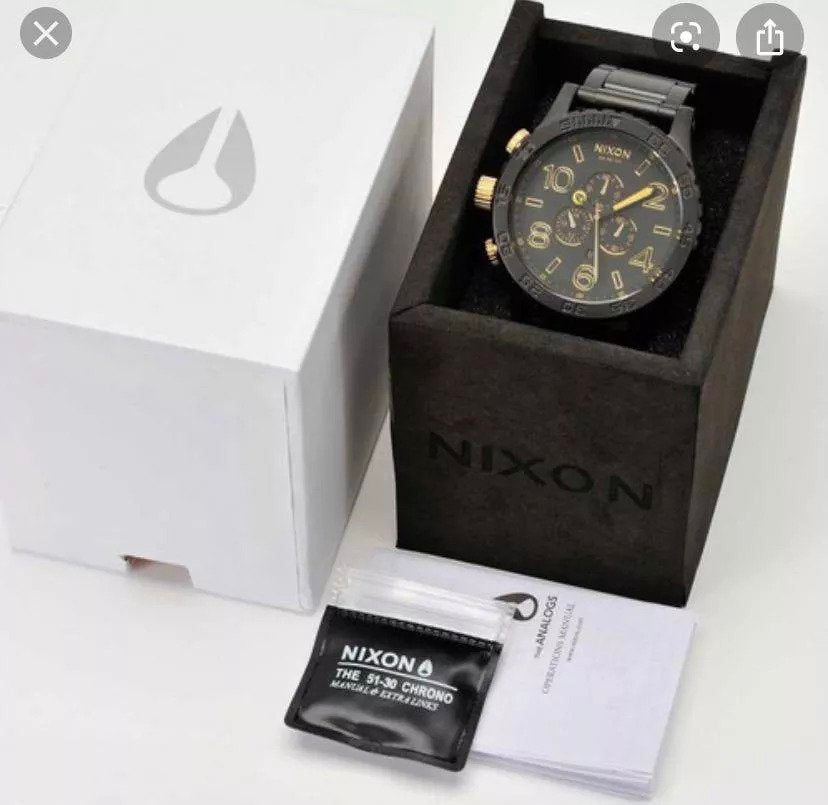 Nixon 51-30 Chronograph Matte Black & Gold Men's Watch A083-1041 in its original packaging with warranty information.