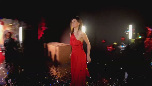 a woman in a red dress standing on a stage