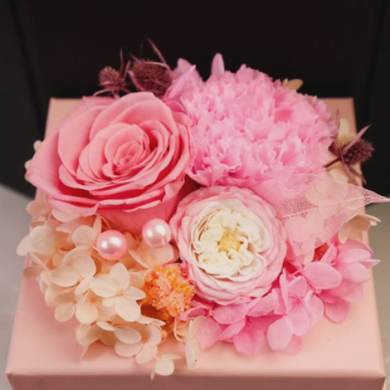 a pink box with flowers and pearls on it