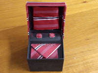 a red tie and matching cufflinks in a box