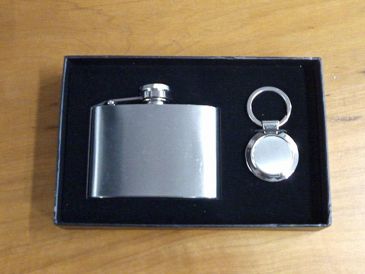 a flask and keychain in a box on a table