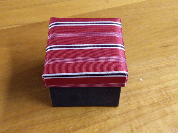 a red and white striped tie sitting on top of a wooden table