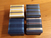 a wooden table topped with four different types of ties