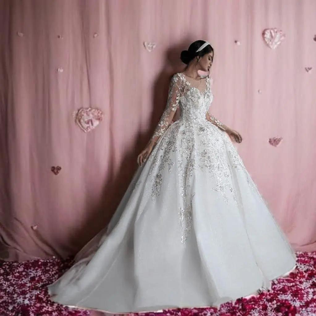 a woman in a wedding dress standing in front of a pink backdrop
