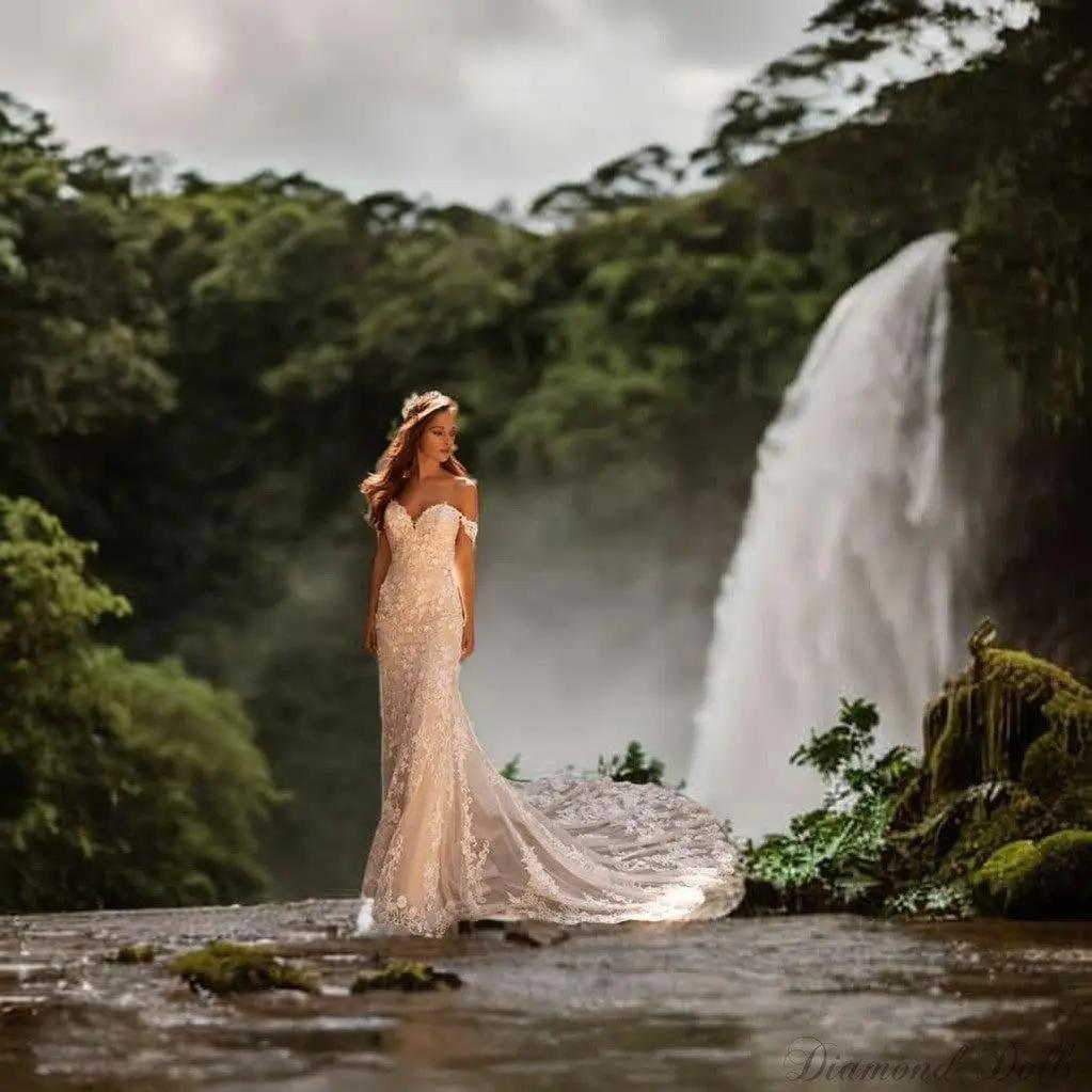 a woman in a wedding dress standing in front of a waterfall